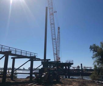 Crane pile driving to construct PetroFuels Barge Dock in Mt. Airy, Louisiana.
